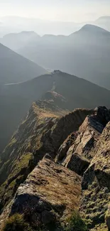 Breathtaking view of a mountain ridge under a misty sky at sunrise.