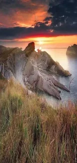 Sunset over rugged coastline with vibrant sky and sea.