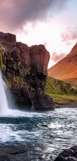 Waterfall over rocky cliffs at sunset, serene nature scene.