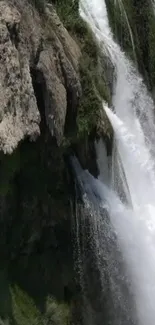 Stunning waterfall cascading over rocks with lush greenery.