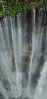 Aerial view of a stunning waterfall surrounded by lush greenery.