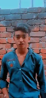 Young man in blue shirt against brick wall background, exuding casual urban style.