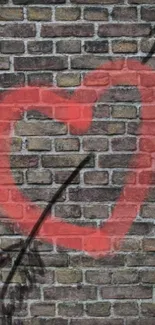 Red heart graffiti on a brick wall with an arrow.