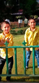 Boys in yellow shirts enjoying a bright day at the park.