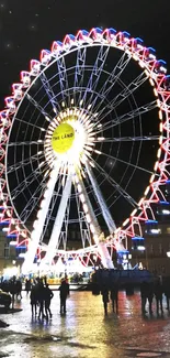 Ferris wheel illuminated at night against a dark sky in a city setting.