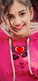 Pink hoodie with artistic design on mobile wallpaper.