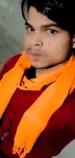 Portrait with bright orange scarf and maroon shirt.