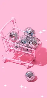 Pink shopping cart with disco balls on a vibrant pink background.