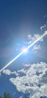 Bright blue sky with sun and white clouds.