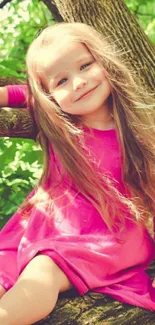 Girl in pink dress smiling on tree branch.