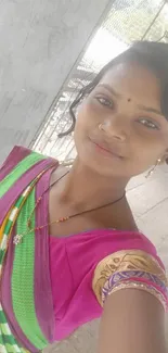 Woman in colorful traditional attire smiling.