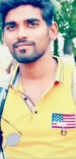 Young man in yellow shirt with sunglasses and backpack.