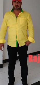 Man wearing a bright yellow shirt with green accents and black pants.