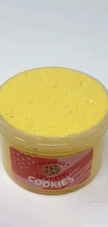 Yellow cookie dough in a jar with confetti label, on a white background.