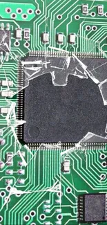 Broken circuit board with green patterns and cracked chip.