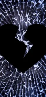 Broken heart silhouette on shattered glass background in dark tones.