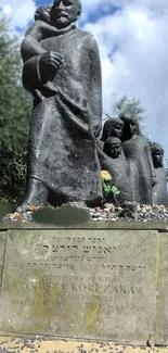 Bronze memorial statue in a sunny park with trees and a stone base.