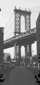 Black and white photo of Brooklyn Bridge with urban street view.