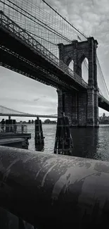 Monochrome view of the Brooklyn Bridge spanning over water.