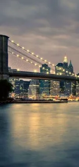 Brooklyn Bridge at night with city lights and reflections on water.