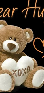 Cute teddy bear with heart and 'Bear Hugs' text on black background.