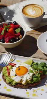 Avocado toast with egg, berries, and coffee on a wooden table.