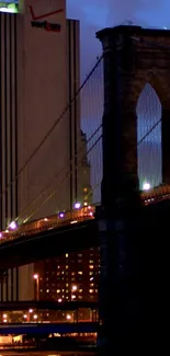 Night view of Brooklyn Bridge illuminated by city lights under a dark sky.