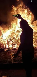 Silhouette in front of a large bonfire at night, creating dramatic visuals.