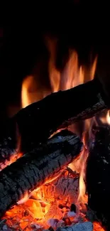 Mobile wallpaper with burning firewood and glowing embers.