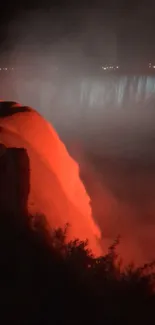 Fiery red waterfall glowing in misty nighttime scenery.