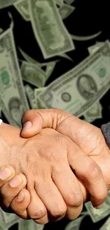 Business handshake with dollar bills in background.