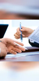 Hands exchanging documents at a meeting table.