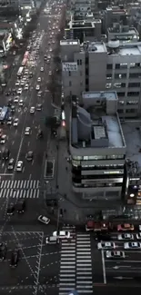 Aerial view of city streets at night with bustling traffic and modern buildings.