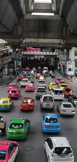 View of city traffic with colorful cars under an overpass.