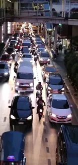 Busy city street with cars and motorbikes in evening traffic.