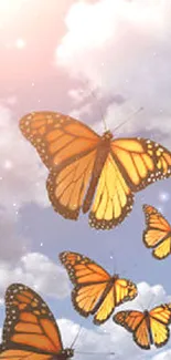 Vibrant butterflies flying in a blue sky with white clouds.