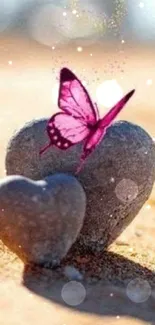 Pink butterfly resting on heart-shaped stones in sand.