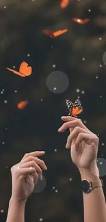 Hands reaching towards fluttering orange butterflies on a dark background.