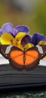 Butterfly on open book with colorful pansies in background.