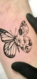 Intricate butterfly tattoo with floral design on skin.