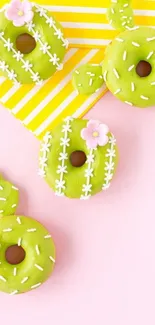 Green cactus-shaped donuts on a pastel pink background.