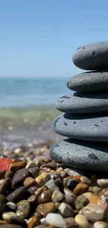 Stacked beach stones with calming sea view and blue sky background.