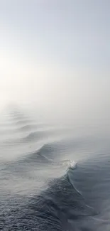 Tranquil ocean waves fading into misty horizon wallpaper.