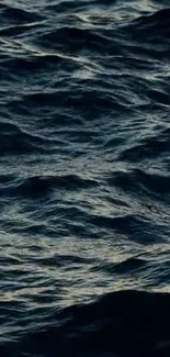Mobile wallpaper featuring calm ocean waves with a dark blue hue.