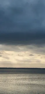 Tranquil ocean view under a moody dusk sky.