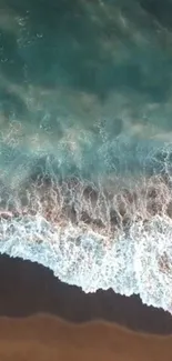 Aerial view of ocean waves crashing on a sandy beach.