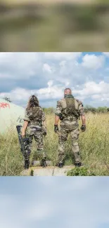 Two soldiers in camouflage stand in a grassy field under a cloudy sky.