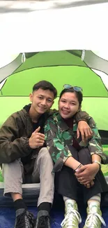 Couple camping inside a green tent