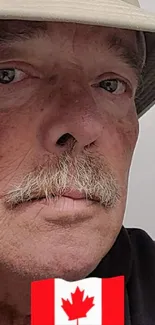 Portrait of a man with hat and Canadian flag overlay on mobile wallpaper.