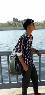 Person in patterned shirt by riverside.